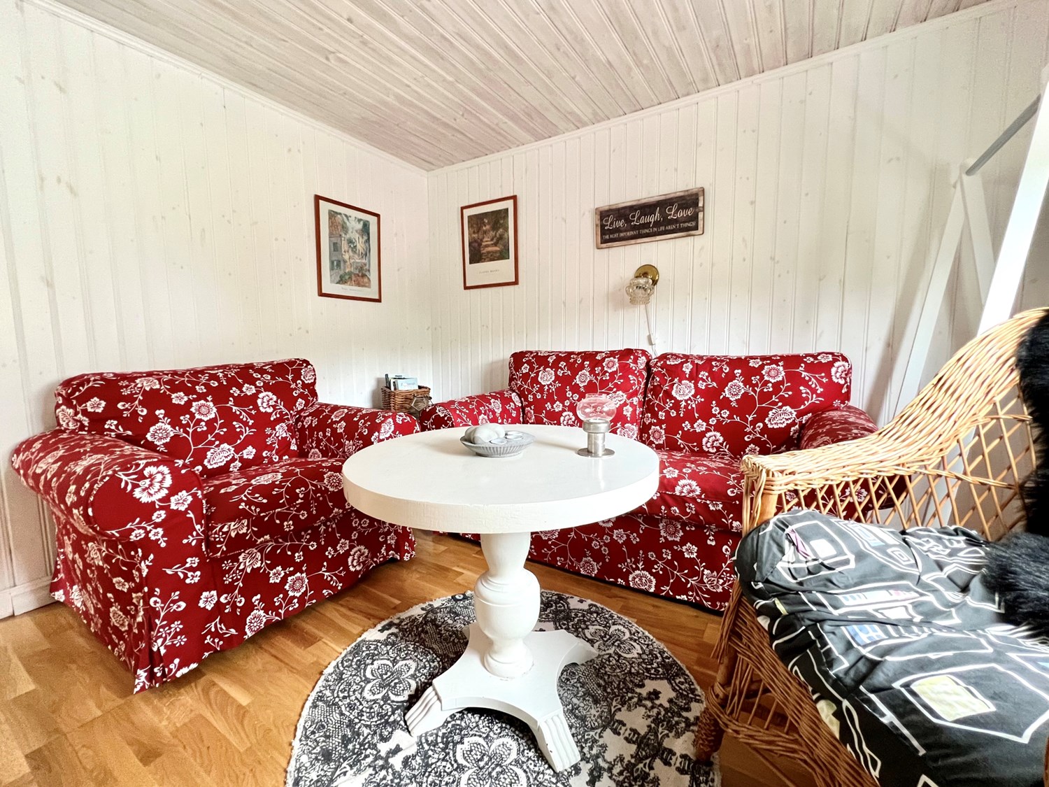Allrum med ekparkett och vitmålad panel på väggar och tak.