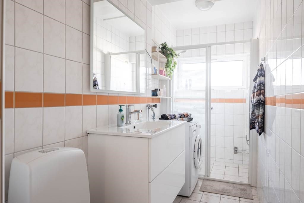 Lågupplöst Helkaklat badrum med värmegolv och tvättmaskin