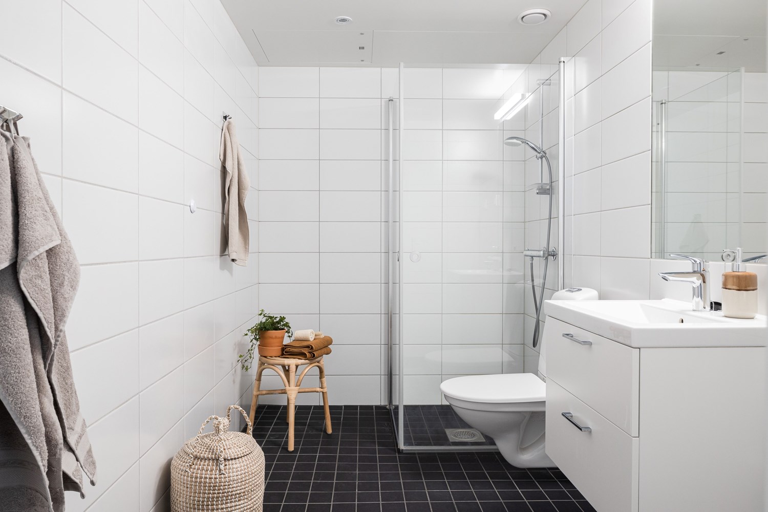 Stort badrum som är helkaklat med dusch och tvättmaskin