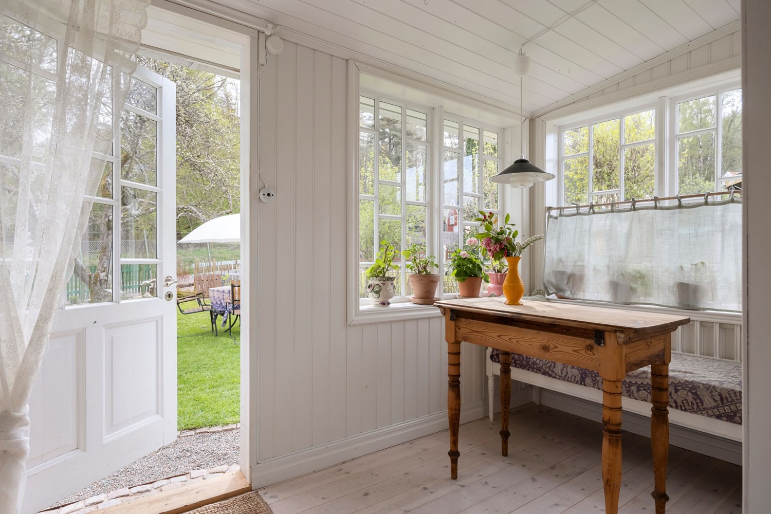 Inbyggd veranda med pärlspont och trägolv