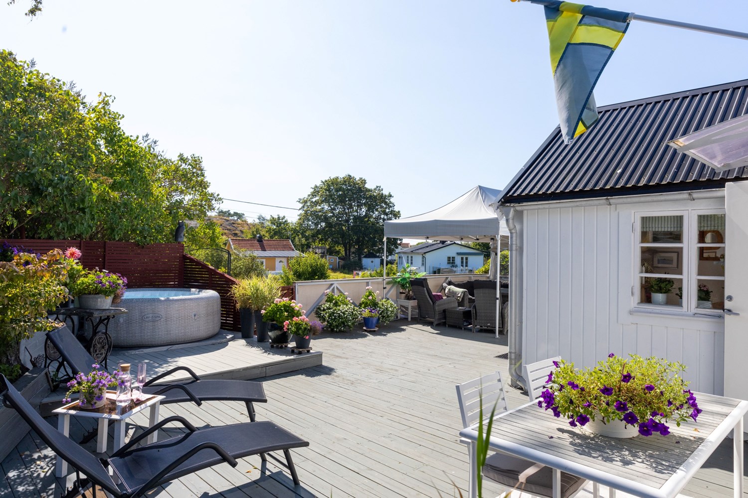 Den stora altanen rymmer solsängar, spabad samt pergola