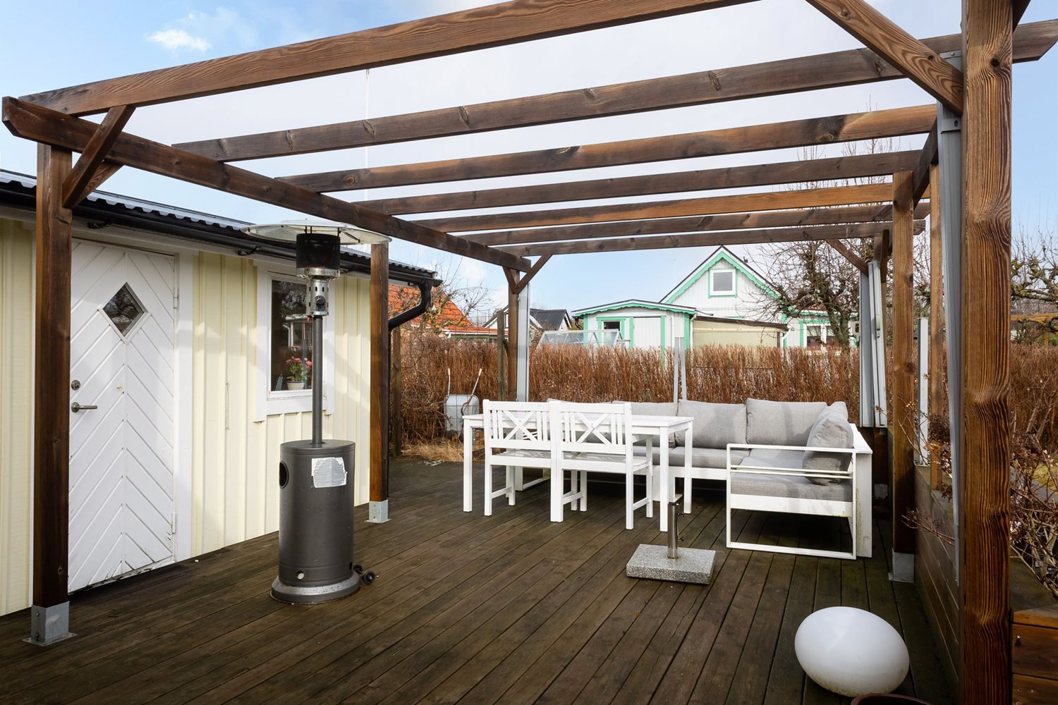 Vy över pergolan och friggeboden