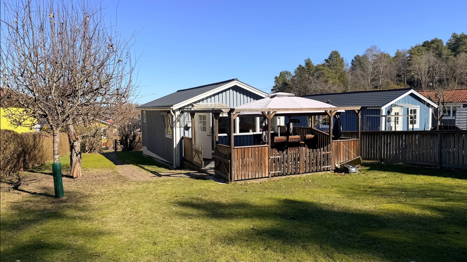 Vy över trädgården på baksidan av stugan