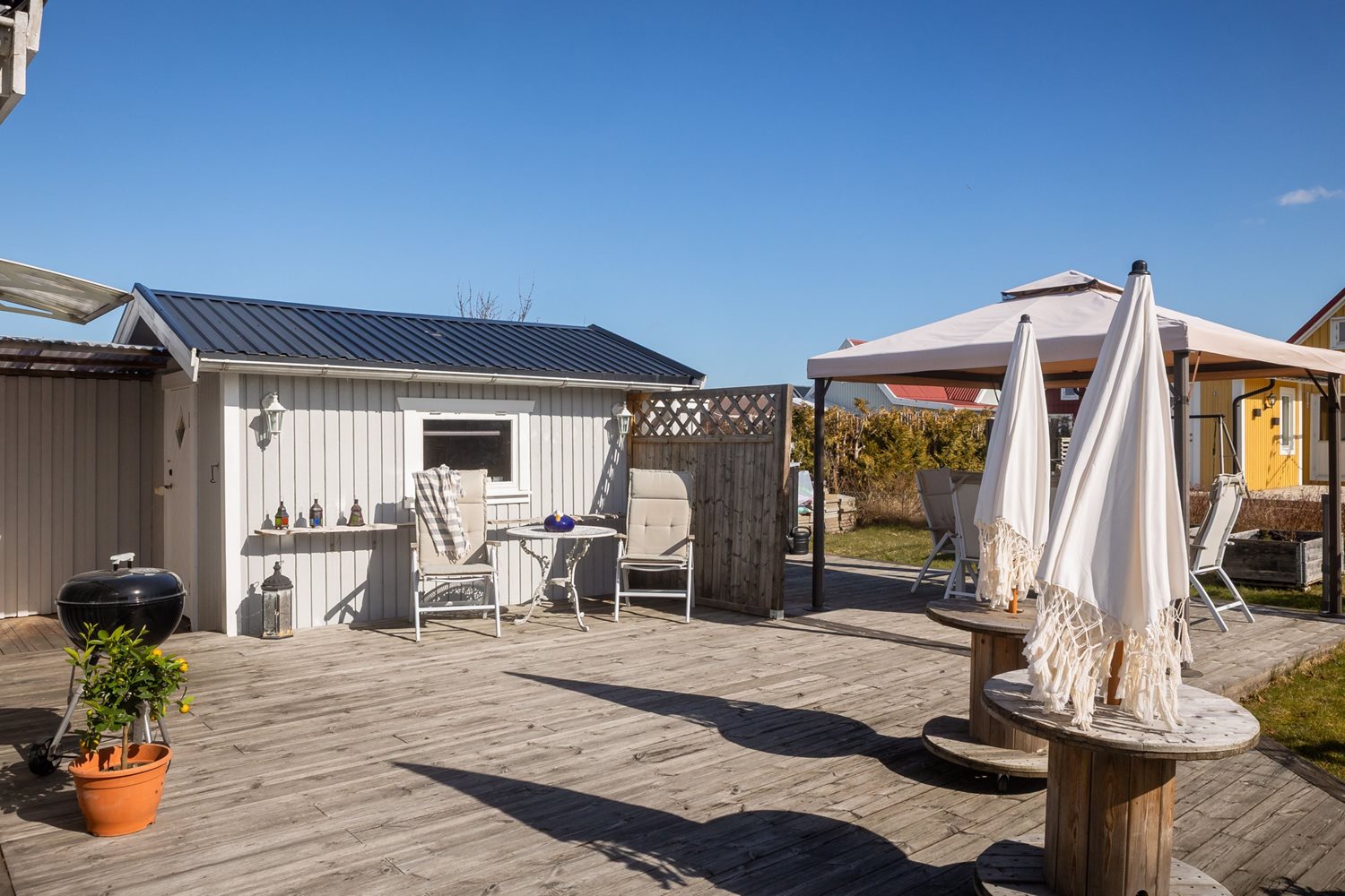 Vy över uteplatsen och friggeboden