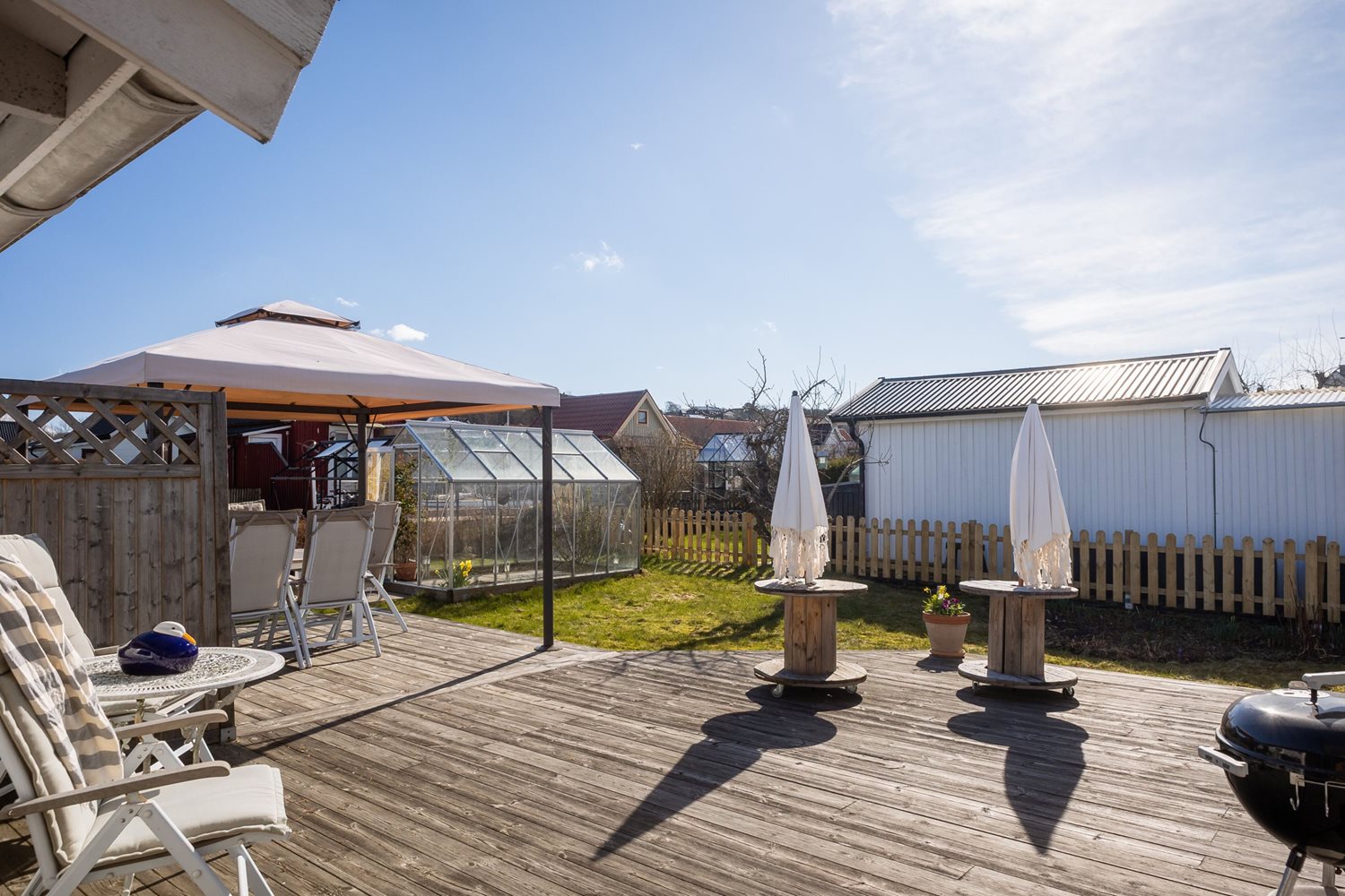 Vy från friggeboden mot uteplats och trädgården