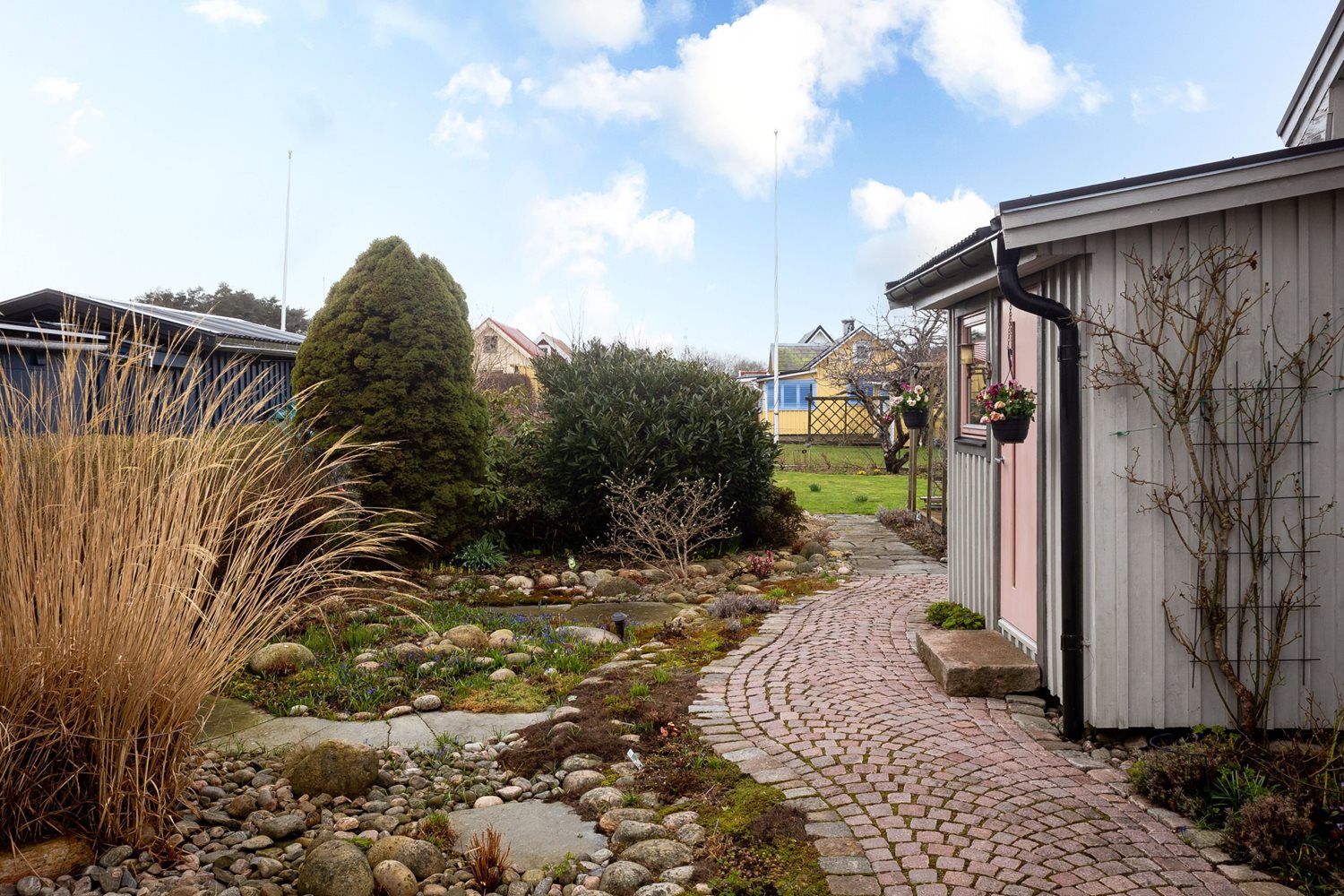 Vy från gången mot stugans entre och trädgård