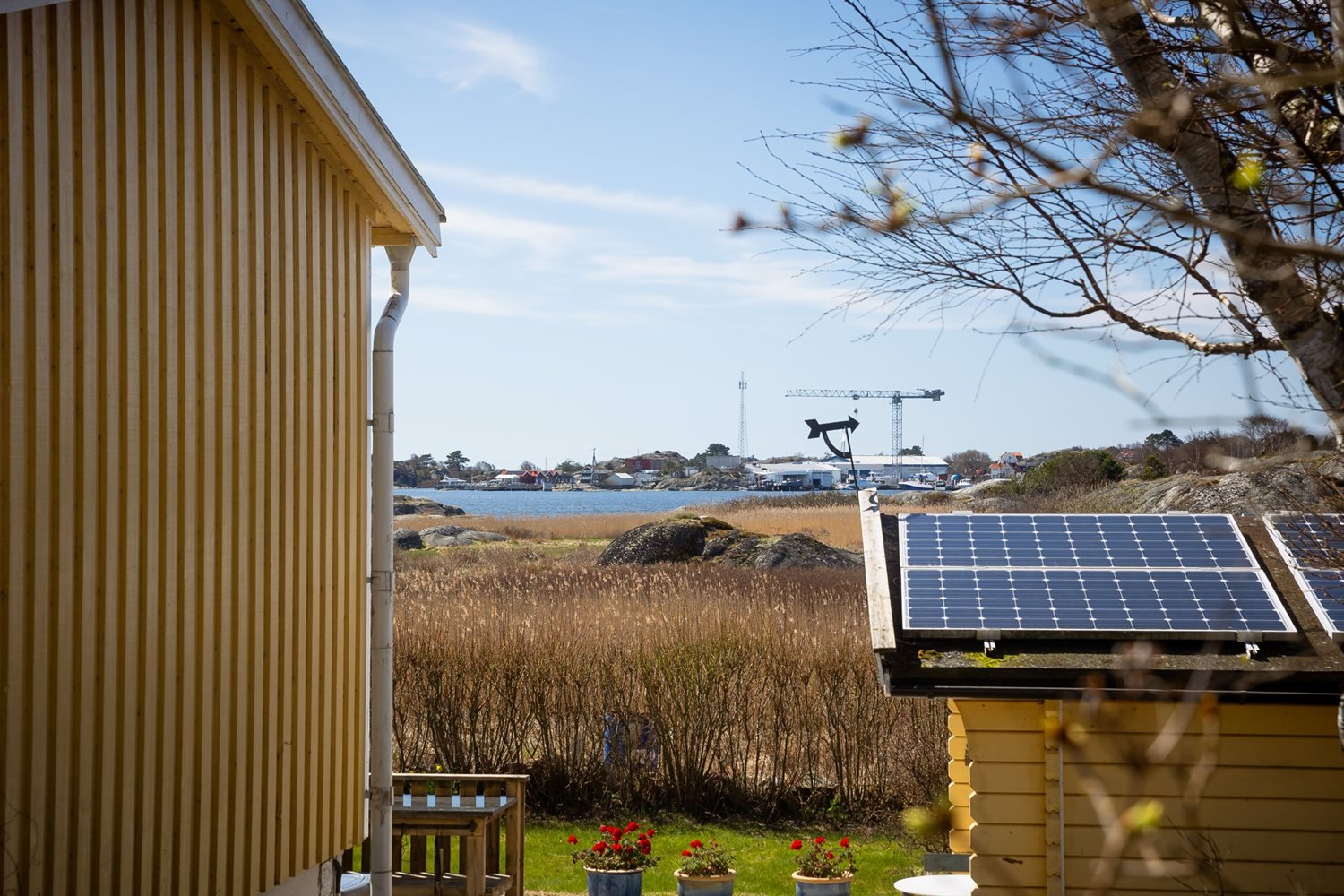 Vy mellan stugan och friggeboden mot havet