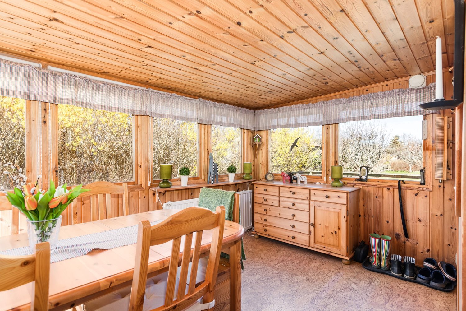 Inbyggd veranda med matplats och många fönster