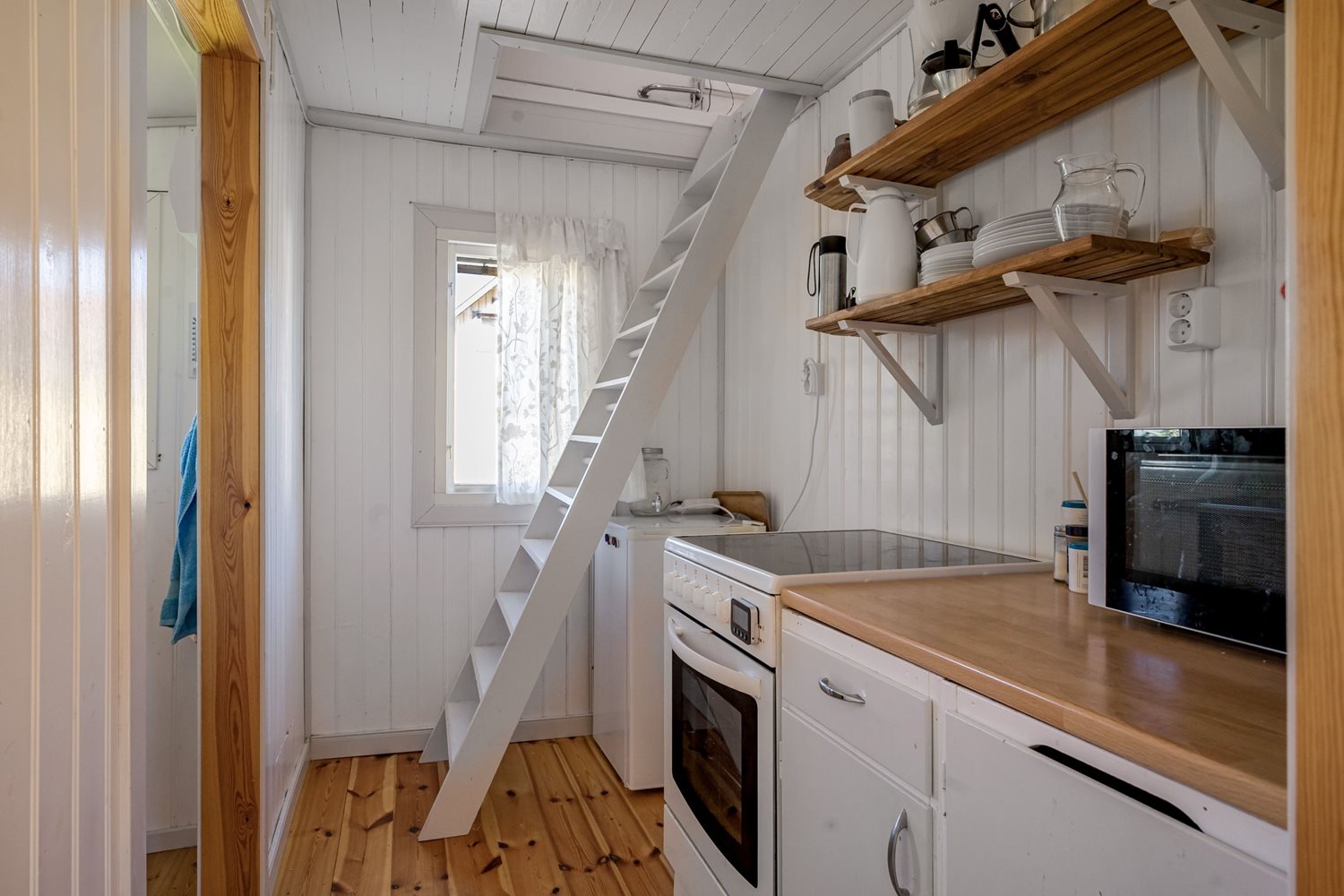 Kök med spis och trappa till loftet