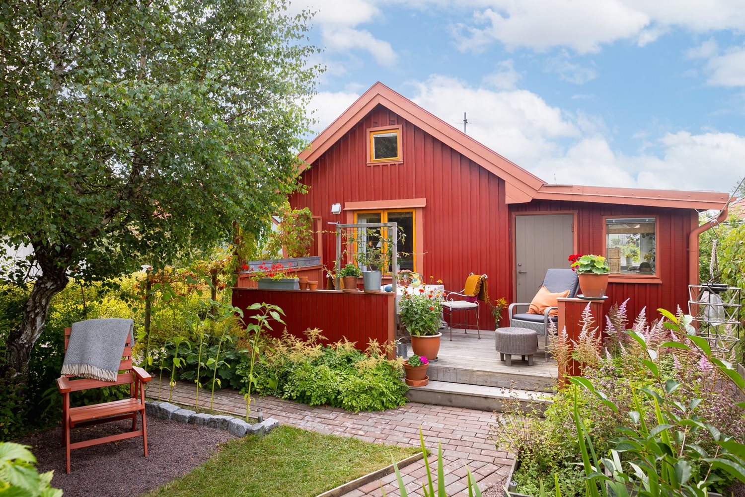 Vy inifrån trädgård mot altan