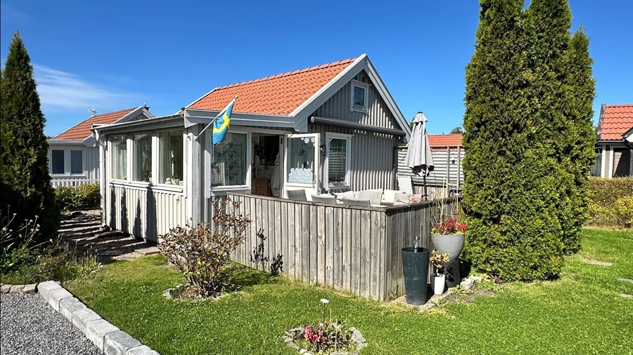 Vy mot stugans altan och inbyggda veranda
